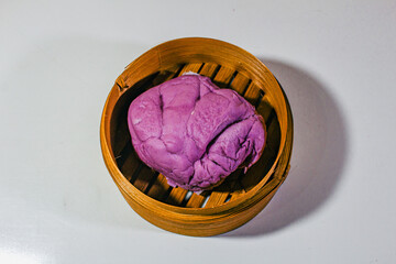 Purple blueberry flavored buns served on a dim sum basket