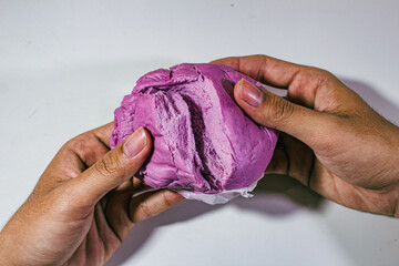 purple buns with blueberry flavor served with two hands tearing them apart