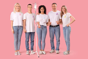 Obraz premium Young woman undergoing chemical therapy course and people with different awareness ribbons on pink background. World Cancer Day