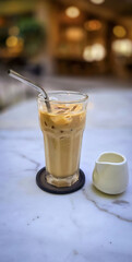 Fresh iced coffee in glass with frothy cream for your design, Food concept in style, copy space