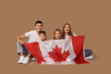 Happy family with flag of Canada sitting on brown background