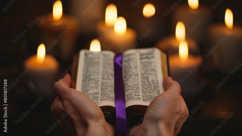 Wall mural hands holding an open bible with a purple ribbon over against the burning candles in the background. - Wall murals