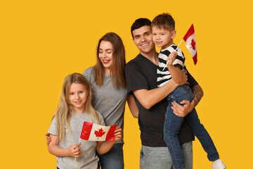 Beautiful family with flags of Canada on yellow background