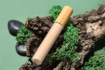 Concealer with tree bark and moss on green background. Eco style concept