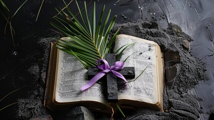 Ash Wednesday concept. Cross and a purple ribbon on top of an open bible covered with ashes. 