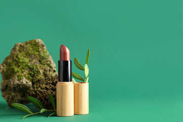 Lipstick with stone, moss and twigs on green background. Eco style concept