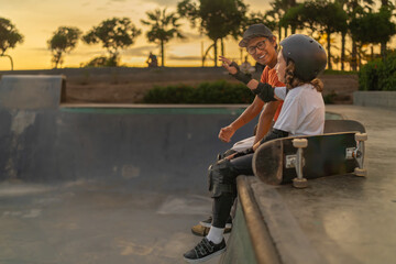 Skateboarder boy talking to his coach at the skate park