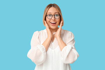 Surprised adult woman on blue background