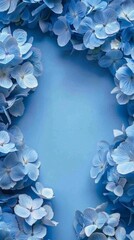 Blue background with a frame of blue hydrangea flowers. Space for text in center