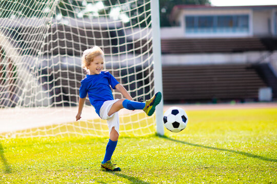 Kids play football. Child at soccer field.