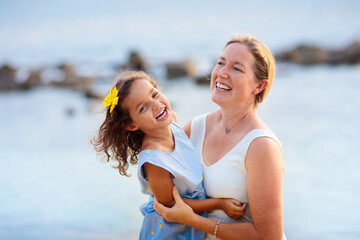 Mother and daughter on tropical beach.