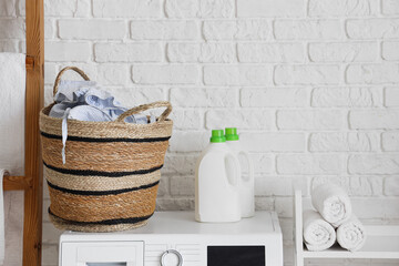 Laundry basket with detergents on washing machine in room
