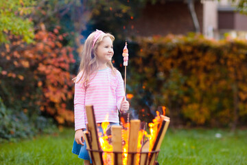 Child with smores at fire. Kids roast marshmallow.