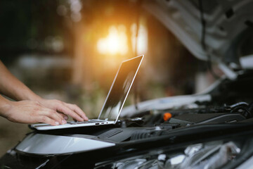 Modern mechanics use laptop computers to check engines. Gather detailed information during work. Industrial plant maintenance services Until engine repair in factories, transportation, cars, vehicles