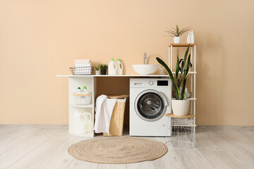 Interior of laundry room with sink, washing machine and basket