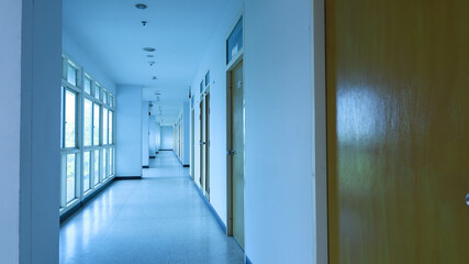 Long hotel corridor. The hotel's corridor is designed to have an open space in front. Long empty white corridor with copy space with selective focus.