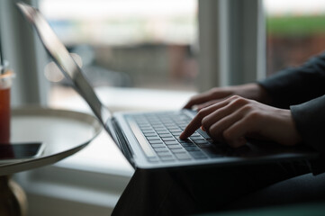 business woman’s hands typing the labtop , young business woman work on labtop in coffee shops.