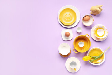 Table setting with Easter eggs, tulip and toy bunny on lilac background