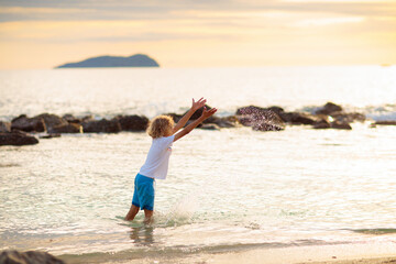 Little boy playing on tropical beach.