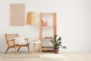Interior of white living room with cozy armchair, houseplant and shelving unit