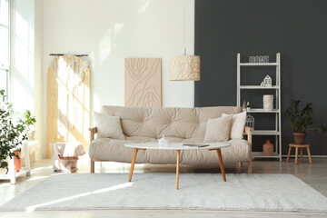 Light interior of modern living room with comfy sofa, coffee table and shelving unit