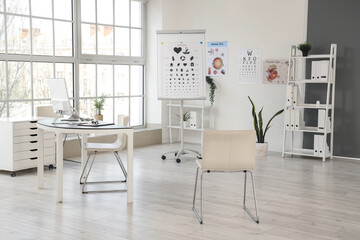 Interior of oculist's office with workplace and eye test charts