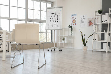 Interior of oculist's office with eye test charts and shelf units
