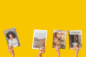 Female hands with different magazines on yellow background