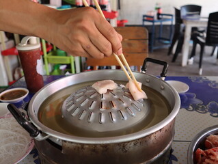 hand holding chopstick delicious Thai style Meat Barbecue