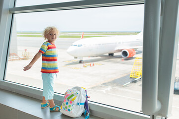 Kids travel and fly. Child at airplane in airport