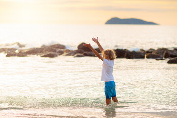 Little boy playing on tropical beach.