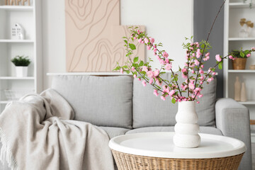 Interior of living room with beautiful blooming branches on table