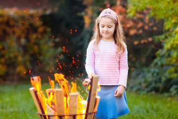 Child with smores at fire. Kids roast marshmallow.