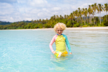 Child on tropical beach. Sea vacation with kids.