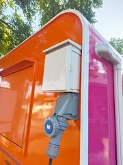 Industrial electric cable sockets are mounted on orange concrete poles.
