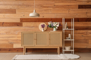 Stylish cabinet and shelving unit near wooden wall in room