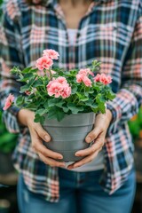 Woman Holding Blooming Pink Geranium Plant at a Flower Greenhouse During Springtime