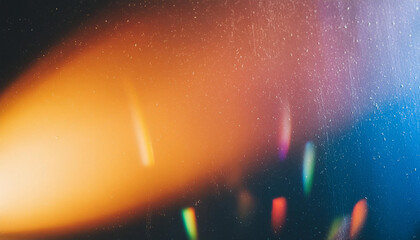 Blur colorful warm rainbow light leaks on black background with dust texture. Defocused abstract damaged scratched retro film analog effect for using over photos as overlay or screen filter