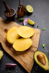 Sliced mango on a wooden cutting board at domestic kitchen