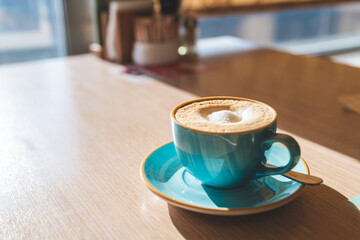 cappuccino in a blue mug with sugar