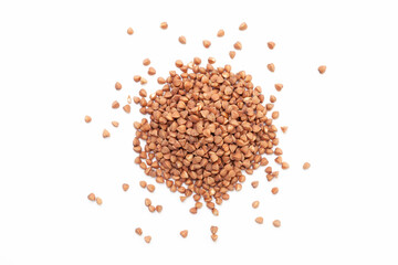 Brown buckwheat grains pile on white background. Dry buckwheat grains. Top view