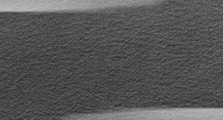 Fototapeta premium Dark gray felt material. Surface of felted fabric texture abstract background in black color with gray vignette. High resolution photo.