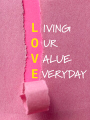 Love acronym word behind torn paper - living our value everyday text background. Stock photo.