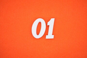 The number 01 is made from white painted wood placed on a background of orange paper.