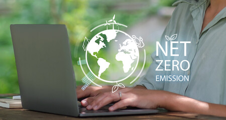 Net zero carbon neutral with ev cars, wind turbines, solar panels, and recycling icons concept, reducing emission and carbon dioxide, laptop tech green natural background.
