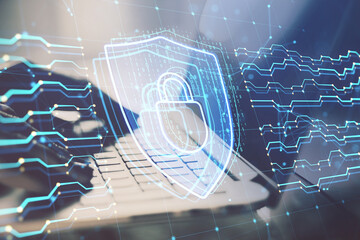 Close up of female hands using laptop keyboard with glowing digital padlock hologram on blurry background. Safety and security concept. Double exposure.