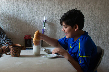 Photo of a grandfather sharing coffee and breakfast with his grandson at a plastic table with a...