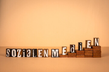 Social Media text in German. Wooden alphabet letters on a light background