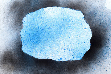 White paper with blue spray stains with black and blue spray painted torn paper frame.