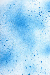 White paper with blue spray stains. Textured background.